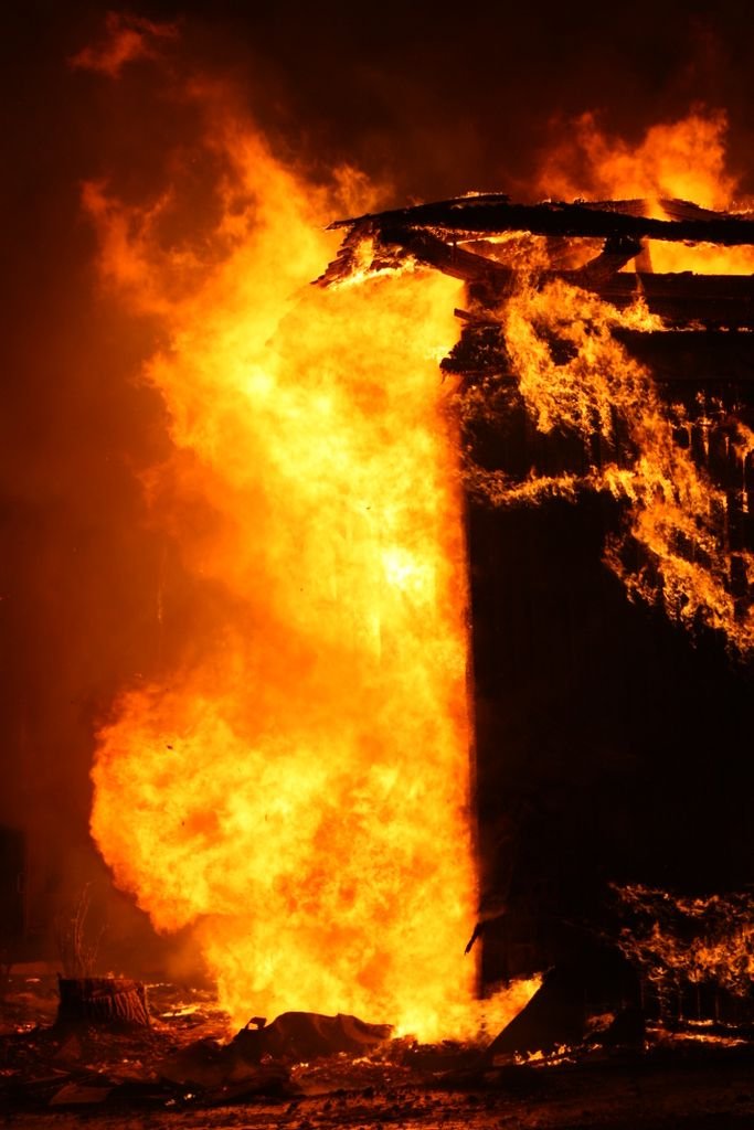 Dramatic image of a building engulfed in flames at night, showcasing danger and intensity.